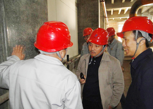 项目执行经理赵书成、工程师冯小强向王总介绍清水镜面砼施工情况